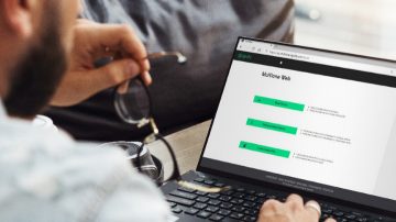 Hand interacting with laptop with MultiOne software