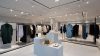 Iluminación blanca sobre prendas exhibidas en tienda de moda