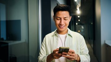Persona usando una aplicación para teléfono inteligente para controlar la iluminación conectada