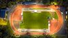 Campo deportivo al aire libre, intensamente iluminado por las luces del estadio
