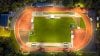 Campo deportivo al aire libre, intensamente iluminado por las luces del estadio