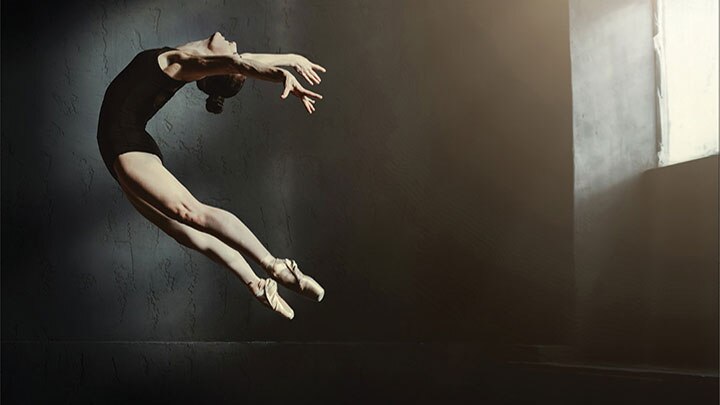 ballerina leaping in window light
