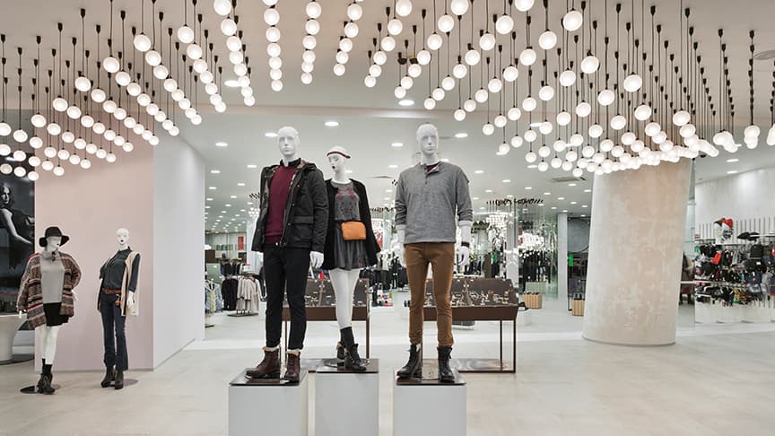 Modern retail store interior with illuminated clothing displays