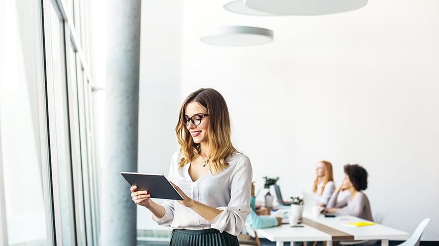A woman in a modern office using a tablet