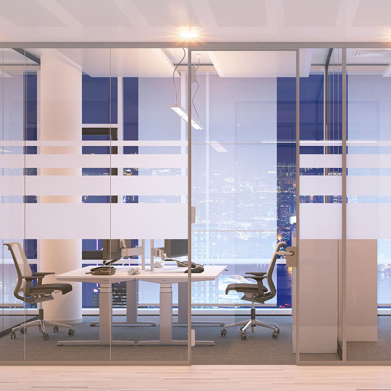 A modern office with glass-partitioned workstations, ergonomic chairs, and floor-to-ceiling windows overlooking a city skyline at night