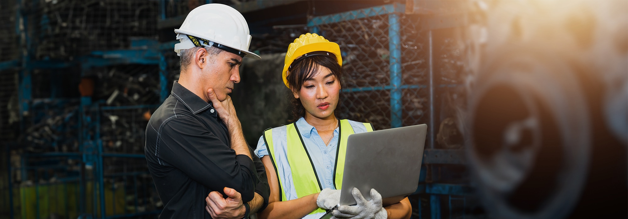 Two construction workers discussing over a laptop