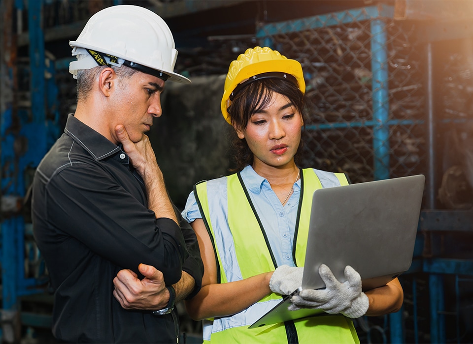 Two construction workers discussing over a laptop