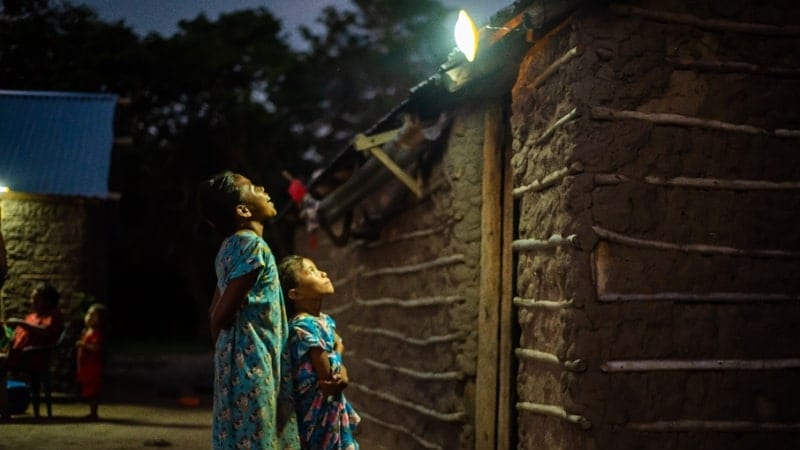 children standing under solar flood light