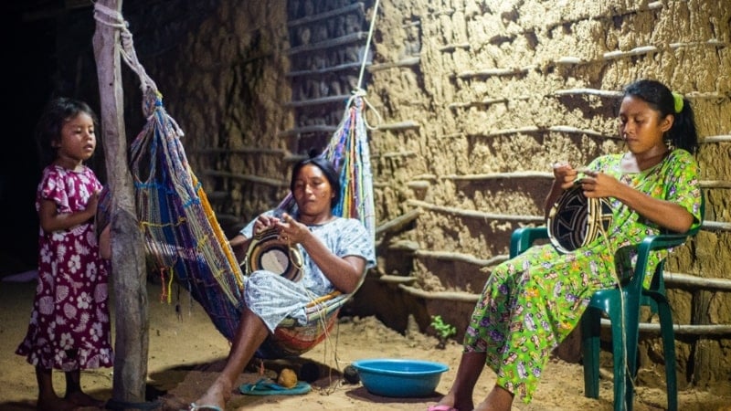 women weaving baskets under outdoor solar lights