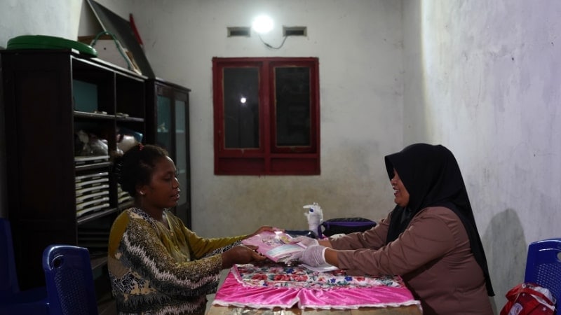 nurse and patient under solar-powered lightbulb