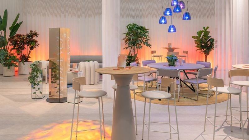 Cityscape viewed from above, framed by lush green plants and trees