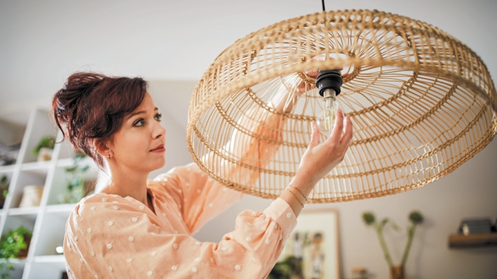 A woman installing an led bulb