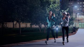 People running at night in a lit park 