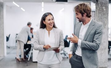 A woman and a man talking and smiling in an office