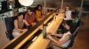 Group of people sitting at a shared desk using their devices