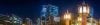 Night-time city buildings illuminated with blue and yellow lighting